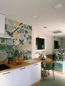 a kitchen with a table and a tile wall at Amodiño do Camiño in Belesar