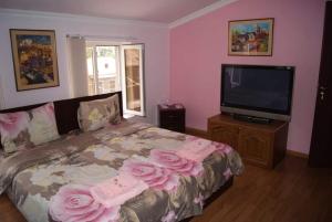 a bedroom with a bed with pink roses on it at BONJOUR HOUSE in Yerevan