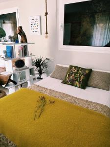 a bedroom with a bed with a yellow blanket at Amodiño do Camiño in Belesar