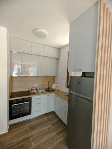 a kitchen with white cabinets and a stainless steel refrigerator at Apartment Laterna in Budva