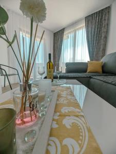 uma sala de estar com uma mesa com um vaso de flores em Apartment Laterna em Budva