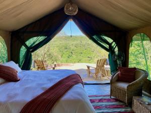 a bedroom with a bed and a window with a view at Echoes of Eden: Forest Haven in Melewa