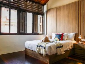 a bedroom with a bed in a room with windows at Carnarvon Antique Loft in George Town