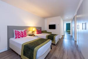 a hotel room with two beds and a television at Orange County Alanya in Okurcalar