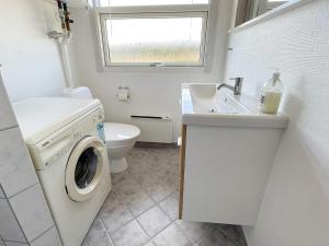 a bathroom with a washing machine and a sink at Three-Bedroom Holiday home in Glesborg 47 in Fjellerup Strand