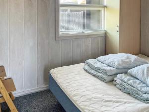 two beds in a room with a window at Three-Bedroom Holiday home in Glesborg 47 in Fjellerup Strand