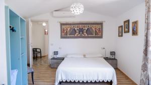 a bedroom with a white bed and a chandelier at Affittacamere DOMO AGORA' in Tertenìa