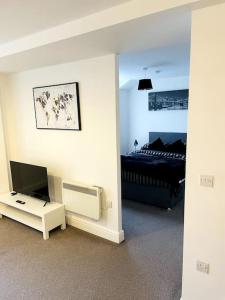 a living room with a television and a bed at #222 1 Bed Serviced Apartment in Derby