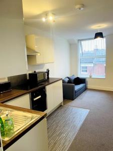 una pequeña cocina con sofá en una habitación en #222 1 Bed Serviced Apartment, en Derby