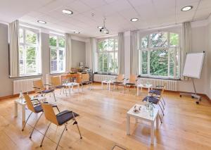 une salle de classe avec des chaises et un tableau blanc dans une salle dans l'établissement Hotel Mutterhaus Düsseldorf, à Düsseldorf