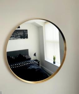 a mirror hanging on a wall in a bedroom at #222 1 Bed Serviced Apartment in Derby