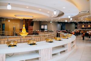 a restaurant with a long counter with food on it at Gold Crest Hotel in Mwanza