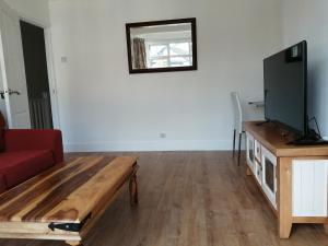 ein Wohnzimmer mit einem Sofa und einem TV in der Unterkunft Lovely 3 Bedrooms Flat Near Romford Station With Free Parking in Romford