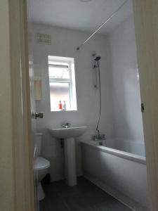 a bathroom with a sink and a tub and a toilet at Lovely 3 Bedrooms Flat Near Romford Station With Free Parking in Romford +18 photos