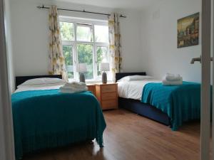 sypialnia z 2 łóżkami i oknem w obiekcie Lovely 3 Bedrooms Flat Near Romford Station With Free Parking w mieście Romford