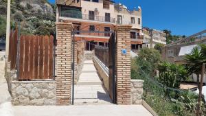 uma entrada para um edifício de tijolos com um portão em Las Terrazas sobre el Mar by Holiday World em Marina di Palma