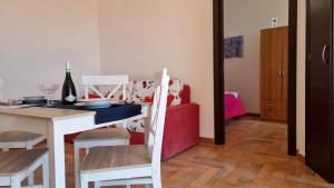 a dining room with a white table and a red couch at Las Terrazas sobre el Mar by Holiday World in Marina di Palma