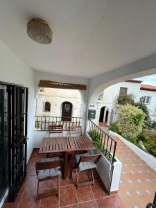 a patio with a wooden table and chairs on a balcony at HACIENDA 12A MENYBER in Nerja