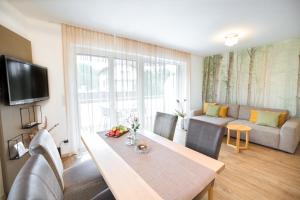 Haus Bachinger في موندزي: غرفة معيشة مع طاولة طعام وأريكة