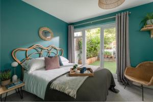 um quarto com paredes azuis e uma cama e uma cadeira em Number 4 - Stylish 1 bedroom house in Truro, Cornwall em Truro