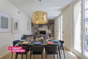 una sala da pranzo con tavolo e lampadario pendente di Riviera Flavour Apartments I by Wonderful Italy a Santa Margherita Ligure