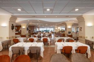 a dining room with white tables and chairs at Savoy Beach Hotel & Thermal Spa in Bibione