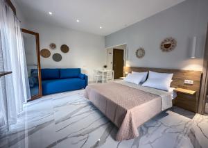 ein Schlafzimmer mit einem blauen Bett und einem blauen Sofa in der Unterkunft MIRA LUXURY APARTMENTS in Paralia Dionisiou