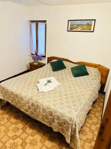 1 dormitorio con 1 cama grande con almohadas verdes en Casa Voje, en Serra Rocco