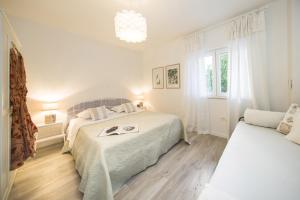 een witte slaapkamer met 2 bedden en een raam bij Apartments by the sea Pisak, Omis - 1067 in Pisak