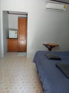 a bedroom with a bed and a wooden cabinet at Maleeya garden guest house in Ko Chang