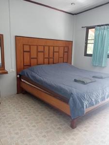 a bedroom with a large bed with a wooden headboard at Maleeya garden guest house in Ko Chang