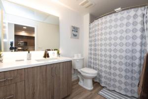 a bathroom with a toilet and a shower curtain at Lux Apt with Rooftop pool by Petco Park and Convention center 41 in San Diego
