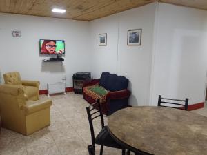 Habitación con sillas, mesa y TV. en Cabañas Comarca de la Quebrada en Potrerillos