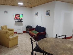 a room with chairs and a table and a tv at Cabañas Comarca de la Quebrada in Potrerillos