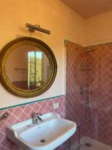 uma casa de banho com um lavatório, um espelho e um chuveiro em Villa Stefania con Piscina em Magazzini