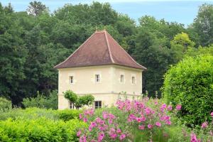 a building with a roof in a field of flowers at Domaine Jean-Got, proche de Saint Emilion in Lugaignac