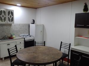 a kitchen with a table and a white refrigerator at Cabañas Comarca de la Quebrada in Potrerillos