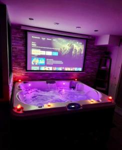 a large tub in a room with a tv at Appartement Love Room/Jacuzzi in Toulouse