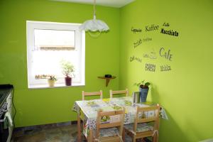 a green dining room with a table and a window at Ferienwohnung Nagel in Steinölsa +4 photos