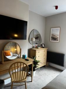 a bedroom with a desk and a tv on the wall at The Crown Pub and Hotel in Manningtree