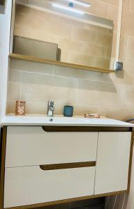 La salle de bains est pourvue d'un lavabo blanc et d'un miroir. dans l'établissement Villa des pruniers, à Saint-Denis