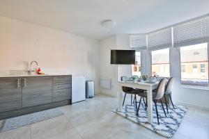 a kitchen with a table and chairs in a kitchen at 1 bedroom apartment near Cardiff Town Centre in Cardiff