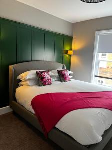 a bedroom with a large bed with a green headboard at The Crown Pub and Hotel in Manningtree