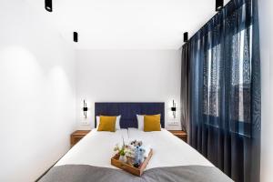 1 dormitorio con 1 cama grande con almohadas amarillas en hotelise I Palermo Apartment, en Ereván