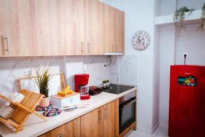 cocina con armarios de madera y nevera roja en Eunoia Luxury Apartment Thessaloniki, en Tesalónica