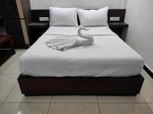 una cama con un cisne sentado encima en Rainbow Inn en Munnar