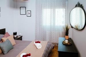 a bedroom with a bed and a mirror and a couch at Eunoia Luxury Apartment Thessaloniki in Thessaloniki