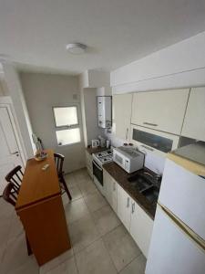 a kitchen with white cabinets and a counter top at Depto en San Nicolás de los arroyos. in San Nicolás de los Arroyos