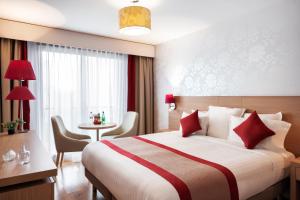 a hotel room with a bed and a table at Residhome Paris-Evry in Courcouronnes +21 photos