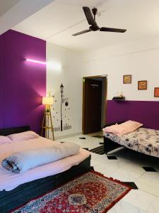 - une chambre avec 2 lits et un mur violet dans l'établissement Raga Homestay 2BHK- A homely guesthouse experience, à Guwahati
